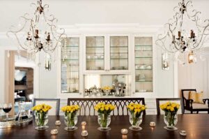 fresh flowers on dining room table in front of glass case built-in