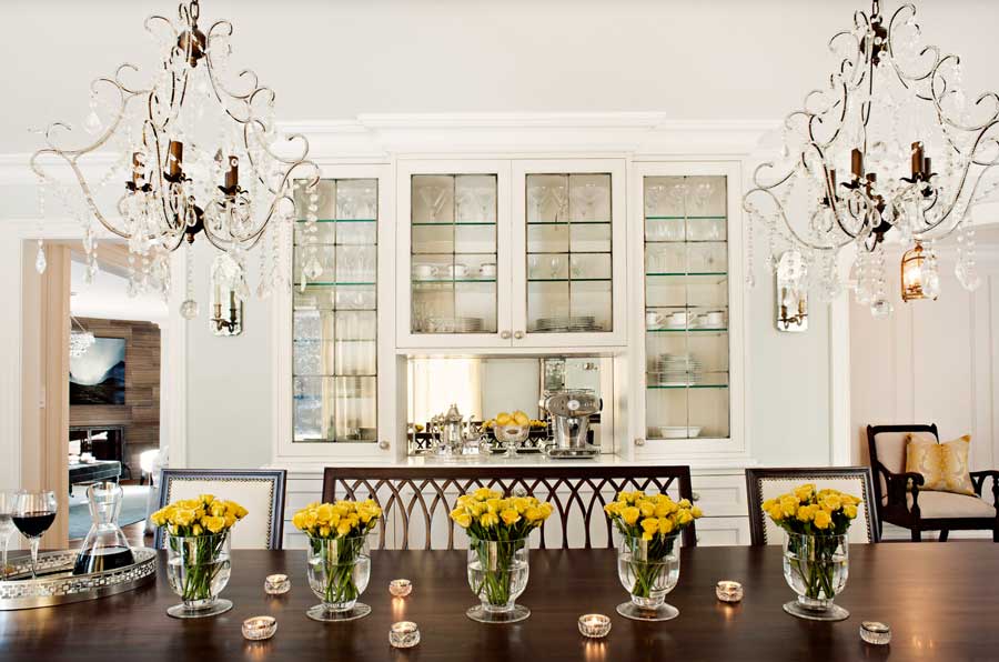 fresh flowers on dining room table in front of glass case built-in