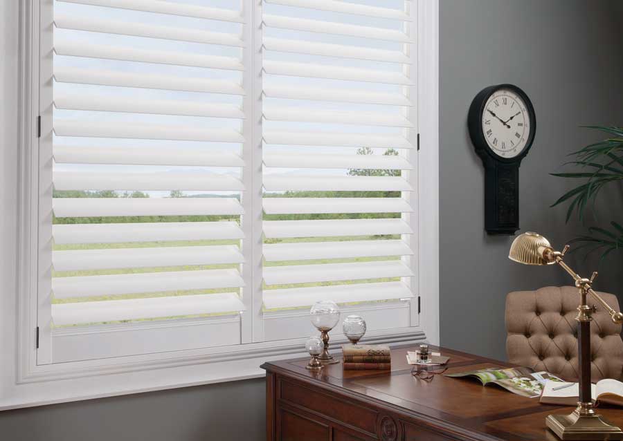 white shutters on window next to desk