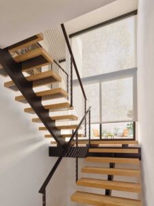 Designer Solar Shades on floor to ceiling windows on a landing of a modern staircase