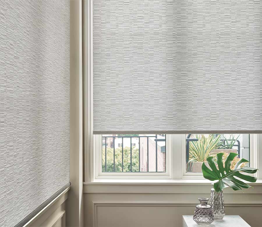 white designer roller shades in corder window