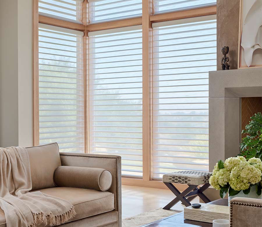 Silhouette® sheer window shades on floor-to-ceiling corner windows, diffusing natural light in a modern Milwaukee living room