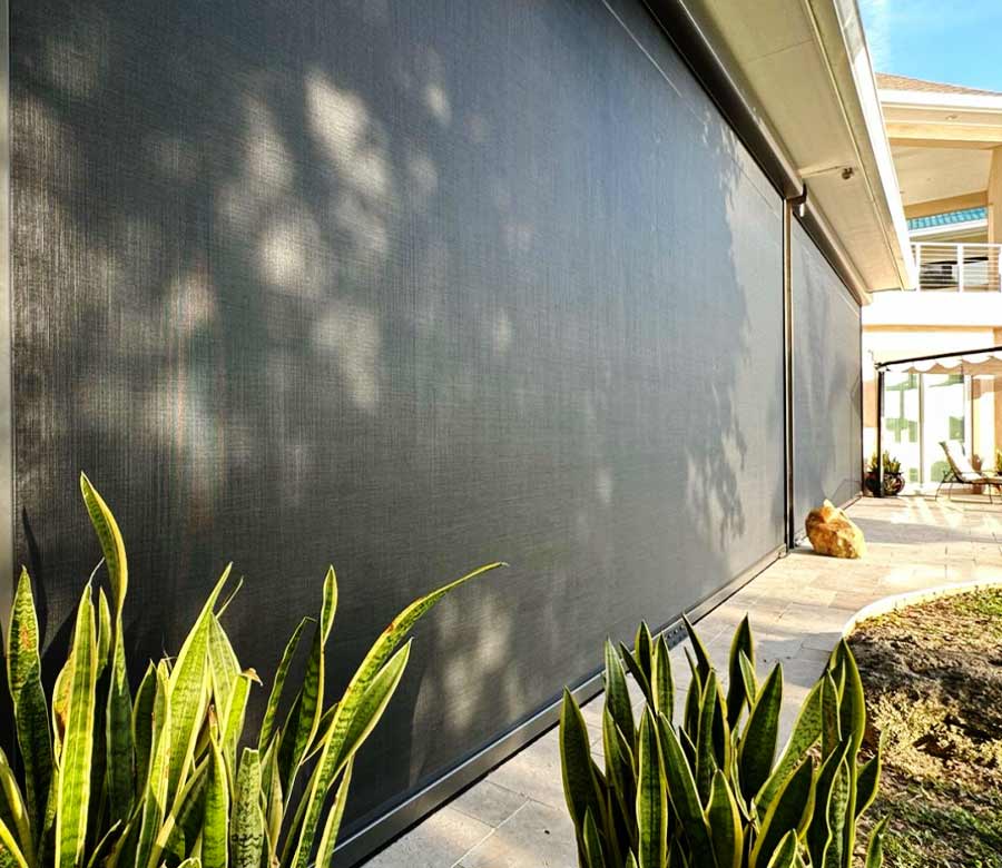 Retractable outdoor shades helping protect a backyard patio from sun and wind