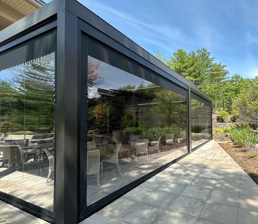 Black exterior patio shades enclosing an outdoor seating area for added comfort
