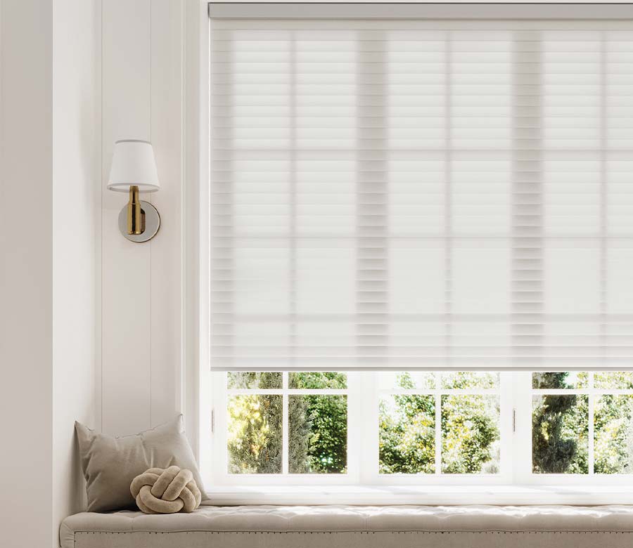 sonnette-shades-window-seat-light-gray-white-hinged-grid-windows-bazaar-home-decorating Light-filtering white cellular window shade above a built-in window seat in a bright living room